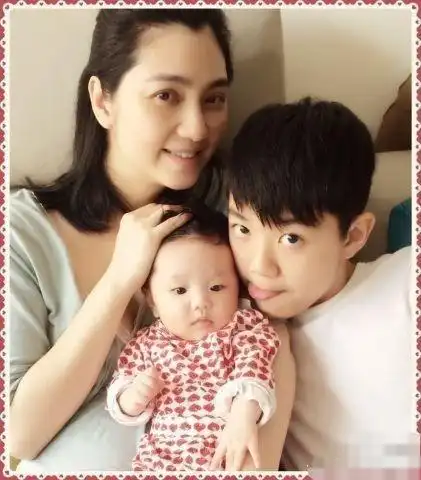 抱着女儿的洪欣也是一脸温柔气质,柔和美丽.