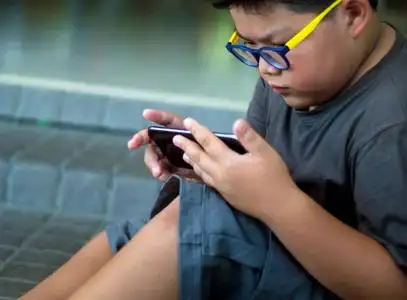 严重的男孩玩智能手机, 孩子们玩智能手机游戏照片