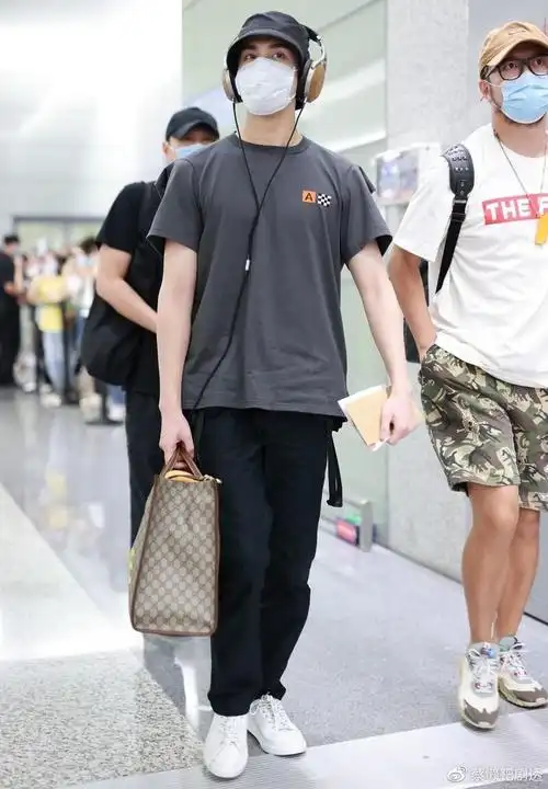 吴磊现身机场,穿搭墨绿色短袖很高冷,头戴耳机目瞪口呆