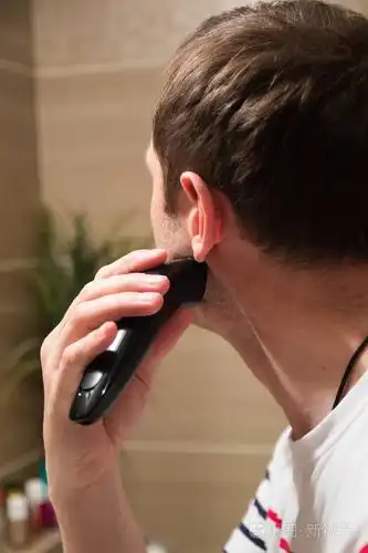 英俊的男人在浴室的镜子前刮胡子照片-正版商用图片0ogngs-摄图新视界