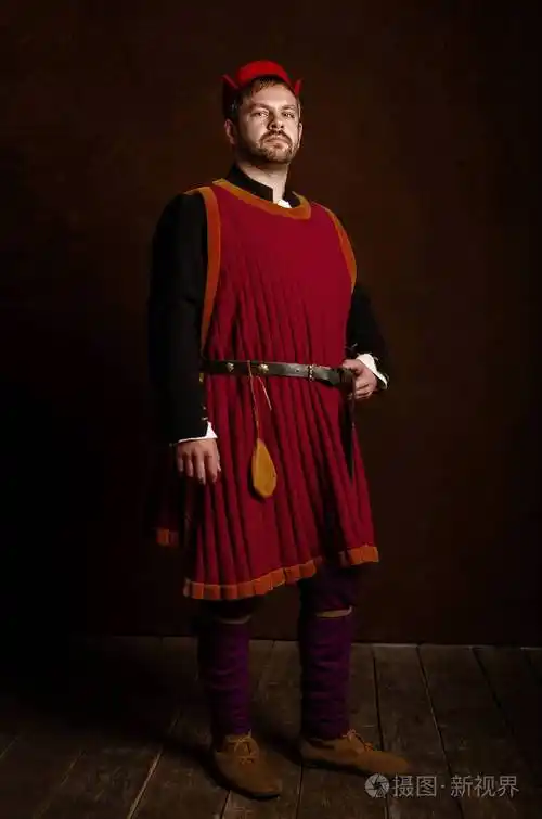男人演员在15世纪的服装中世纪在一个古老的风格背景中世纪生活的爱好