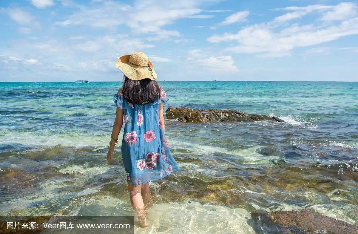 穿着蓝色衣服站在海里的女孩.