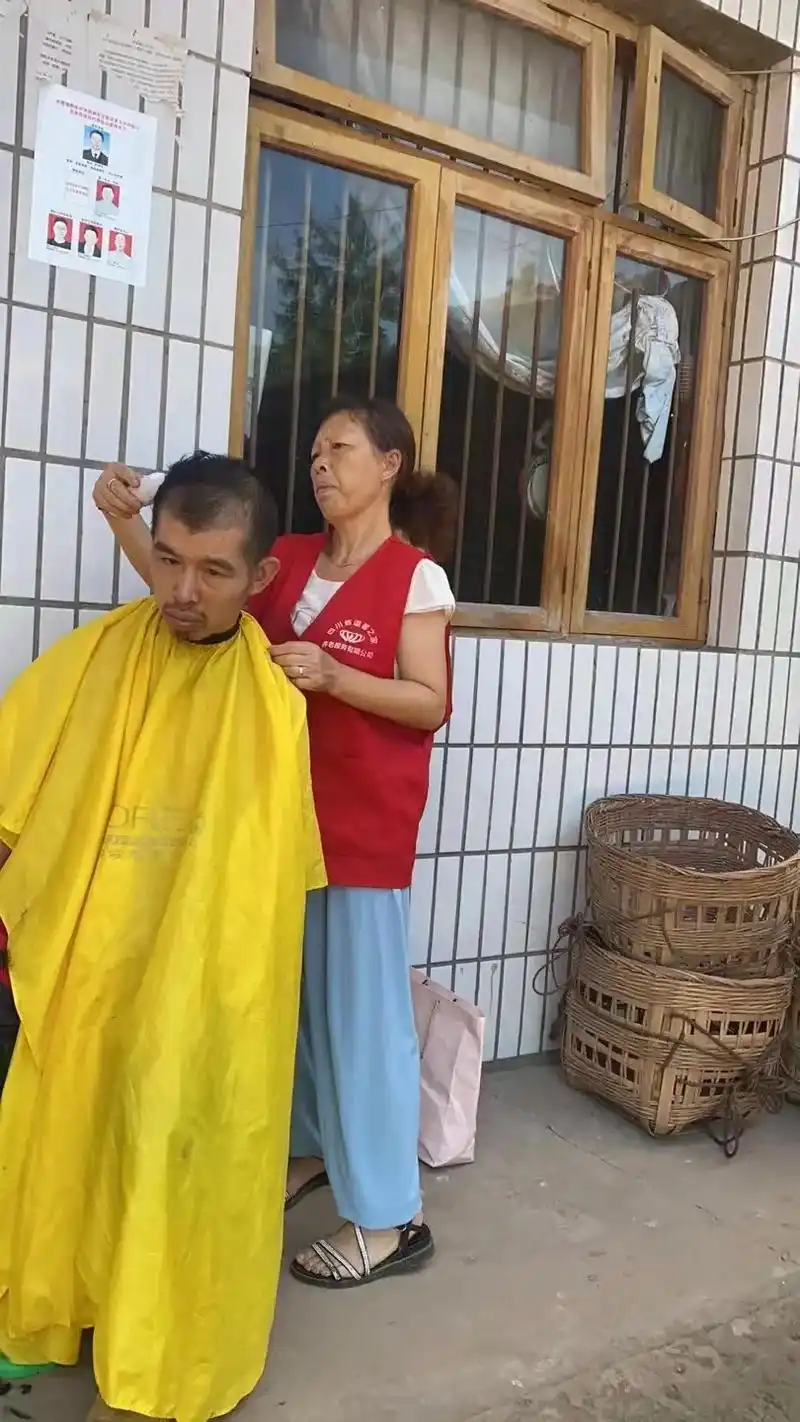 拿着礼品不肯放手的永顺镇智力残疾人陈小刚.