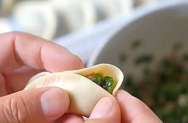 9,两边对起来,捏上褶子捏实合起来.哈哈,这饺子在大手上好小啊!