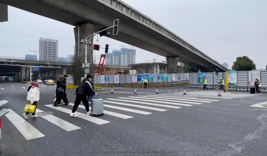 江南路上,行人出站匆匆走过斑马线.