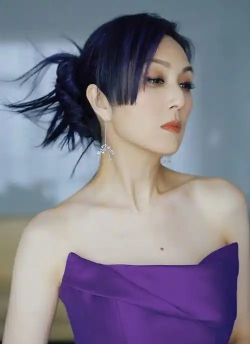 在晒出的照片中,杨千嬅身着一袭优雅的紫色抹胸礼服,尽显女性的柔美与