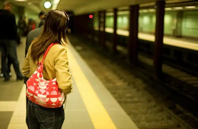 灯光下在站台上等待地铁火车的乘客人物图片