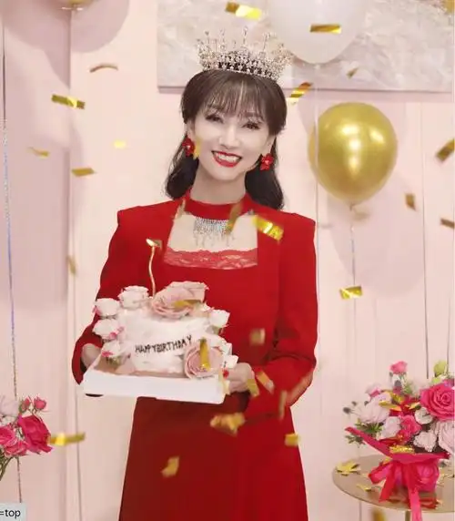 照片中,赵雅芝身着红色的礼服,优雅大方,面带微笑地与周围的人一起