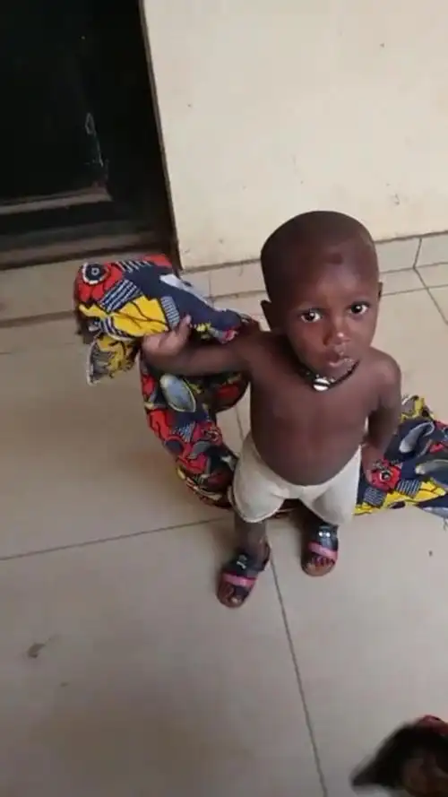 小黑娃睡醒了拿着毯子在玩