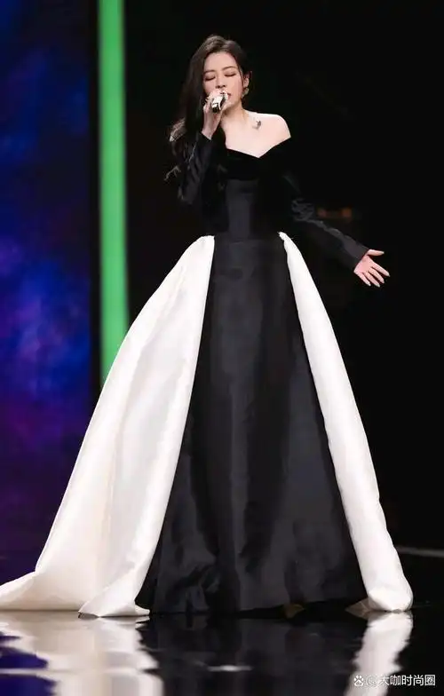 张靓颖身着一套典雅的黑色与纯粹的白色相间的礼服,展现出她独特的的