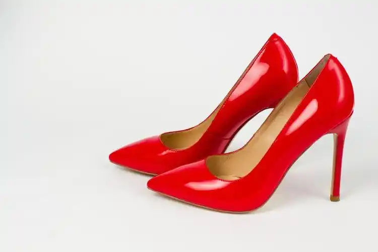 黑色背景中的红色高跟鞋与珠子