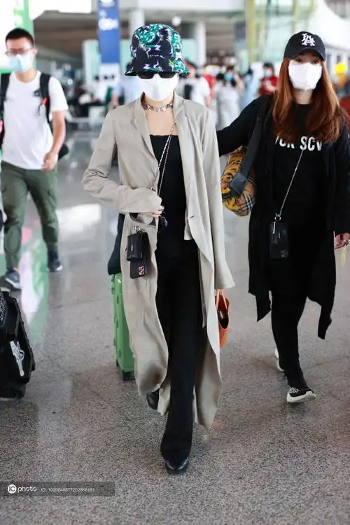 街拍张韶涵卡其色风衣黑色吊带喇叭裤渔夫帽时髦随性