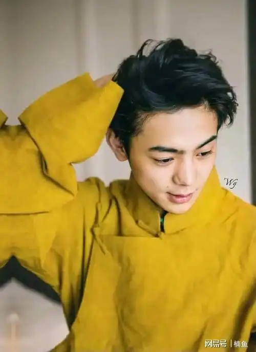 丁真穿着橙黄色的上衣,撩拨头发的那一刻的确很惊