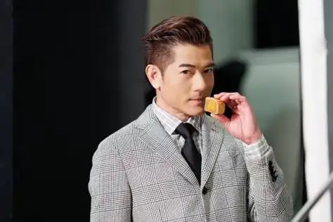 郭富城以灰色格子西装绅士造型出镜,手拿月饼,拍出了大片既视感.
