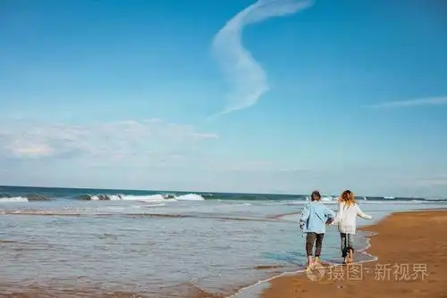 在摩洛哥海岸的沙滩上散步时,情侣们手牵手,玩得很开心