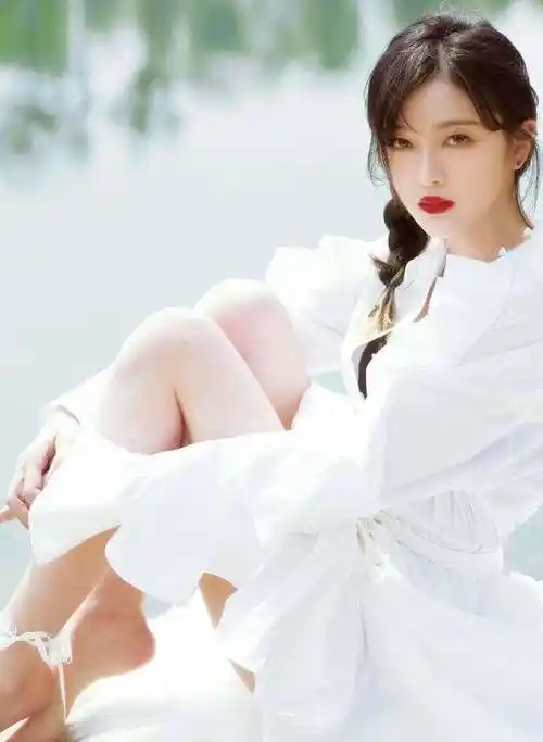 坐在地上的吴宣仪双手怀抱着自己的腿,只有一只脚尖点地.