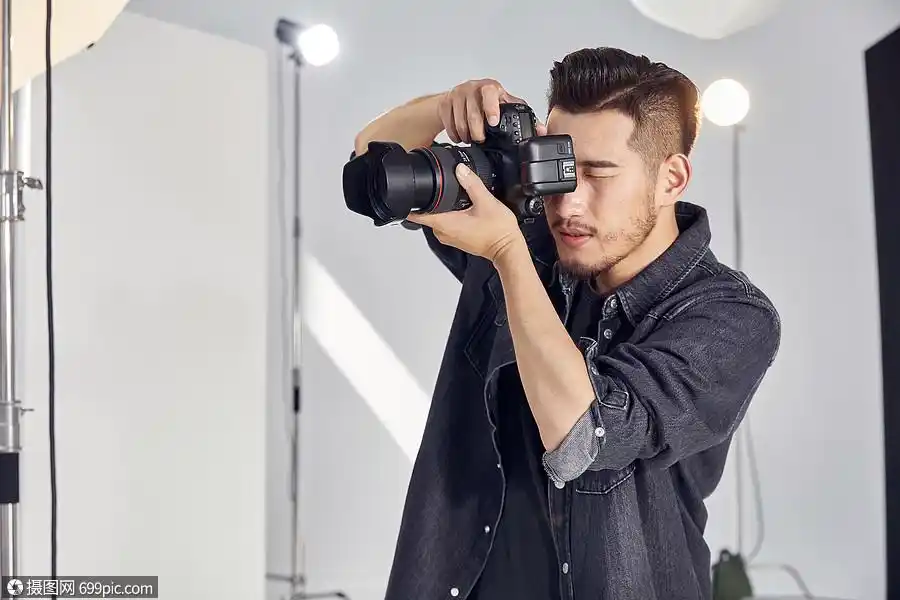摄影师手拿相机拍摄形象工作室影棚