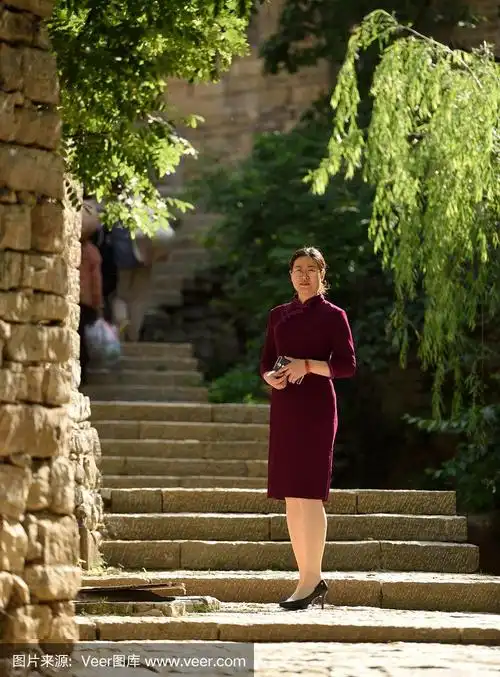 穿着中国传统旗袍的妇女在古村落里拍照