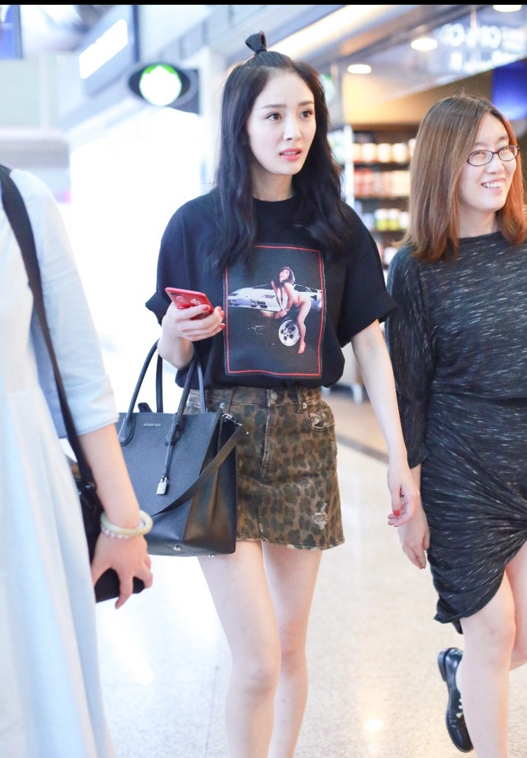 杨幂身穿黑色t恤豹纹短裙现身机场 扎着小揪揪显得活力四射