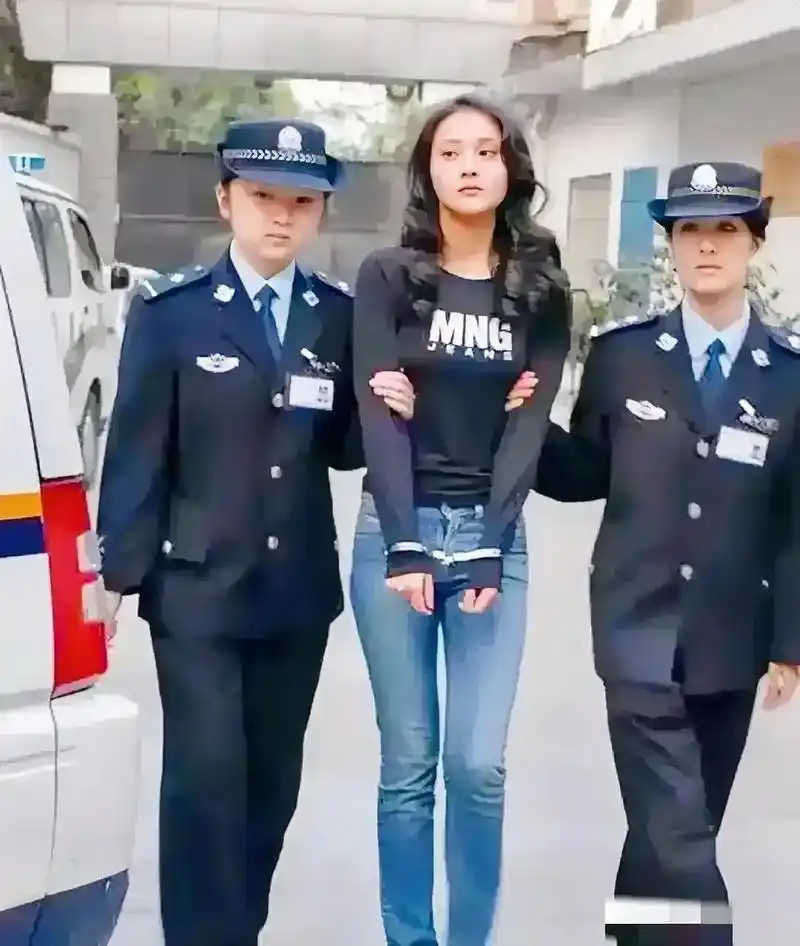 这张照片拍摄于2005年,22岁的毕丽梅,被判处了死刑,被两个法警押解着