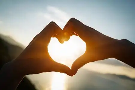 两只手,在天空的心的形状照片