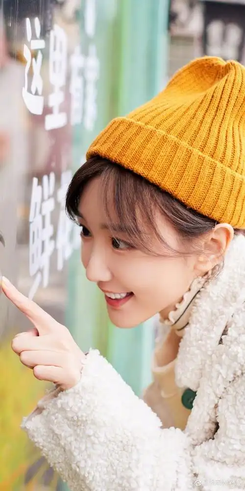 毛晓彤春日小满胡同随拍,橙色帽子怪可爱的,对着镜头浅浅甜笑,是元气