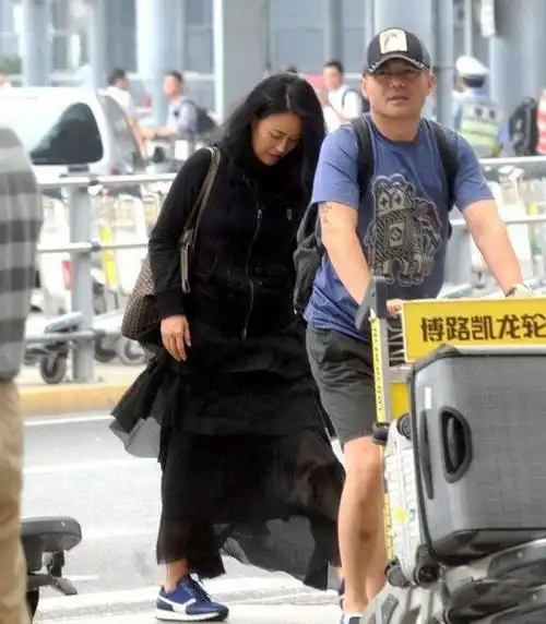 那英跟同岁老公走机场似父女一个嫩成女儿辈一个似中年老头