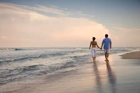 一对在沙滩上散步的情侣照片