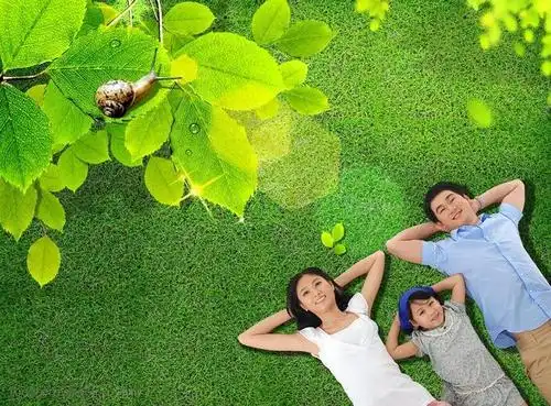 悠闲躺在绿色草地上的一家三口和绿色草地背景