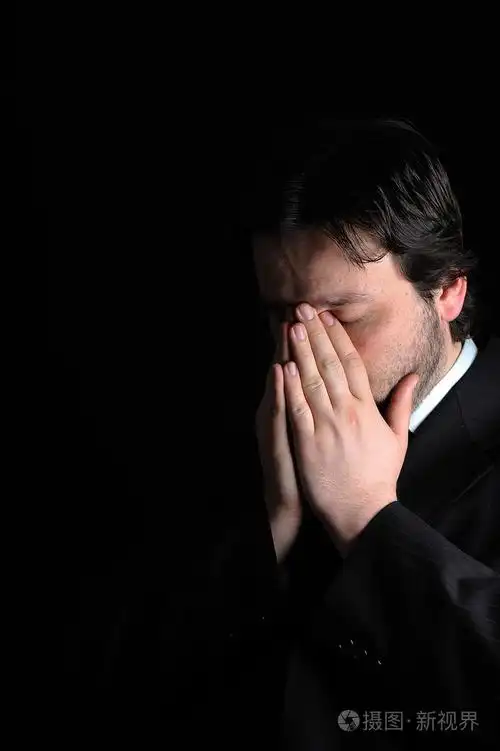 成年商人严肃地思考坐在黑暗的背景下