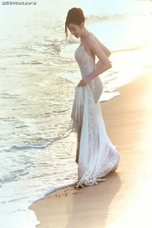 原创张天爱晒美照穿白色透视吊带裙海边漫步赤脚踩沙唯美又性感