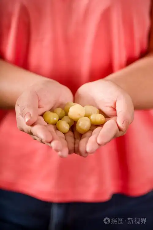 紧紧抓住女人双手捧着一颗星醋栗的果实acidus被称为otaheite醋栗星g