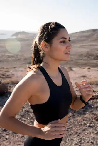 在沙漠中奔跑的妇女的特写和侧面视图在山旁边