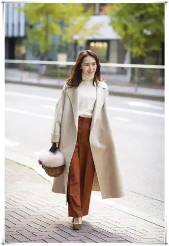 一件双面绒的米色大衣,配上奶白色的高领毛衣,再搭配一条铁锈红的裤子