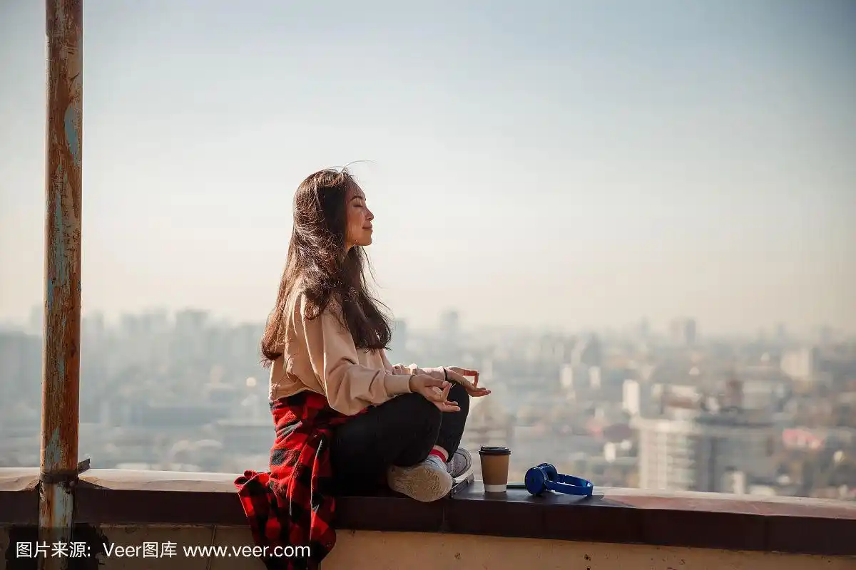 微笑的漂亮女士坐在屋顶上放松