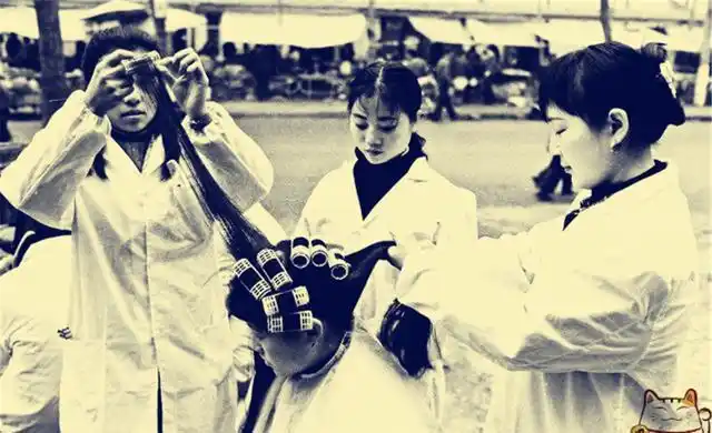 女子在烫发,看起来比较无聊,现在烫发不是看电视就是玩手机.