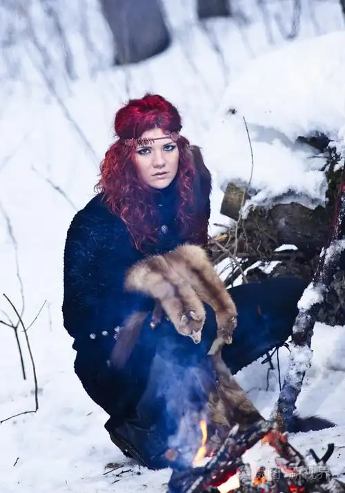 红头发的美丽和野生杨女人在冬季阴暗森林猎人肖像