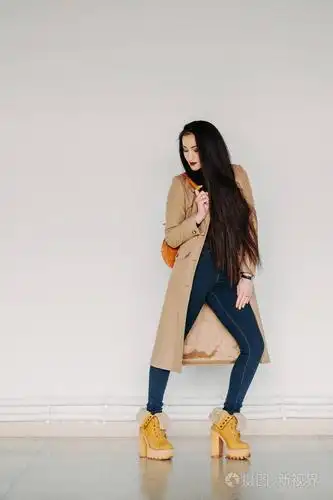 照片 时尚概念: 全身肖像的巨大的灰色墙附近的年轻女孩.