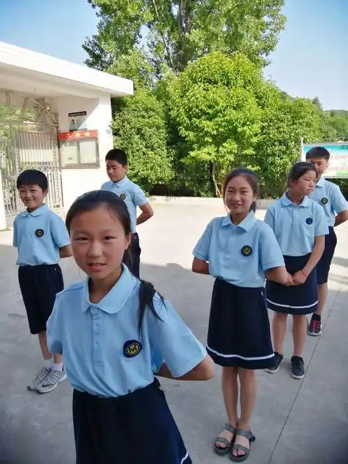 冕亿服饰有限公司的工作人员为孩子们试穿校服.