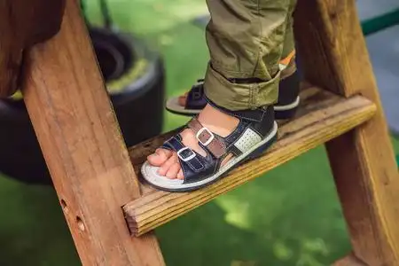 的低截面男孩穿着户外矫形凉鞋的小男孩的脚紫色沙滩凉鞋或拖鞋图标