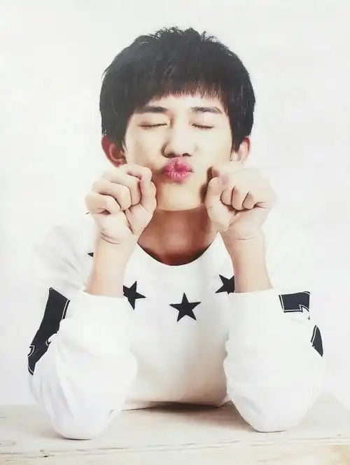 易烊千玺还拍摄过这样的嘟嘴照片,两只手放在嘴巴边上,穿着白色的t恤