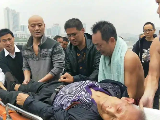人们纷份赞扬黎源的泳者无畏精神.此时吴凡还光着上身抬着老人.