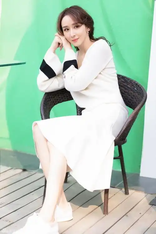 组图:胡静尽享午后时光 慵懒迷人美腿抢镜 : 胡静慵懒地倚坐在室外的