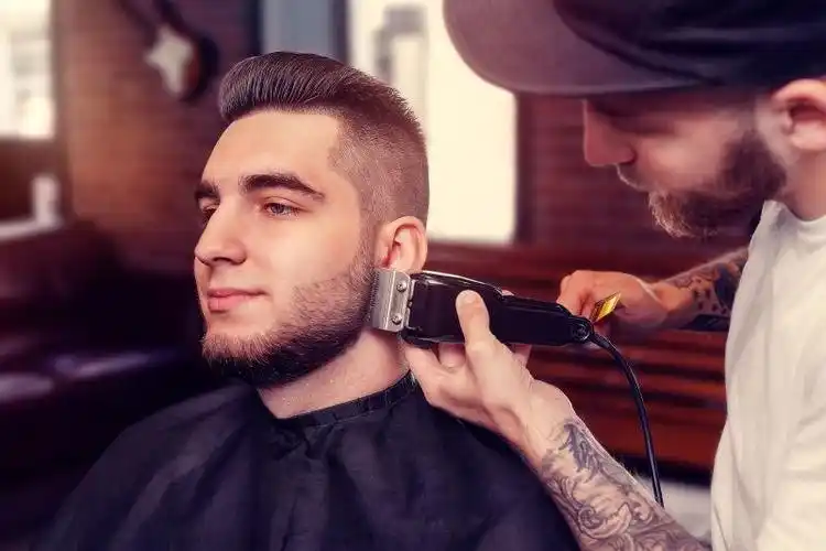 留胡子的年轻人图片-发型师在为男子修理胡须素材-高清图片-摄影照片