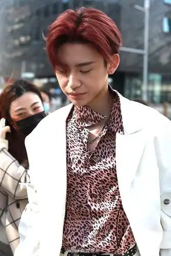 他身着白色西装,内搭粉色豹纹衬衫,顶着红发造型