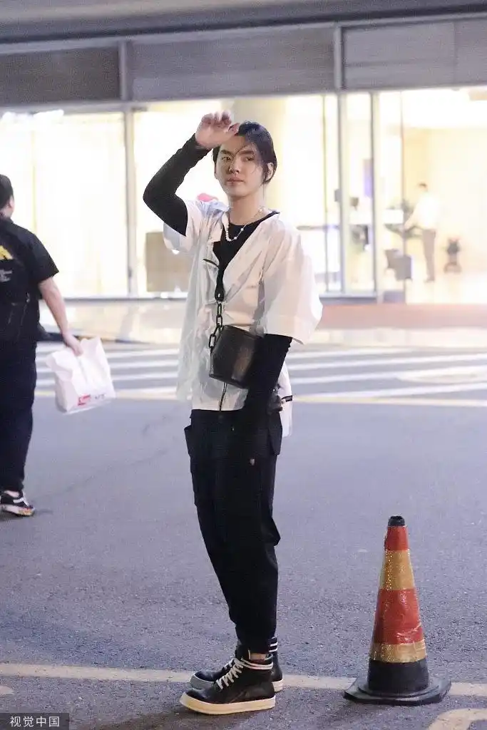 吴亦凡一身潮范现身机场 小长发扎辫帅颜似撕漫男