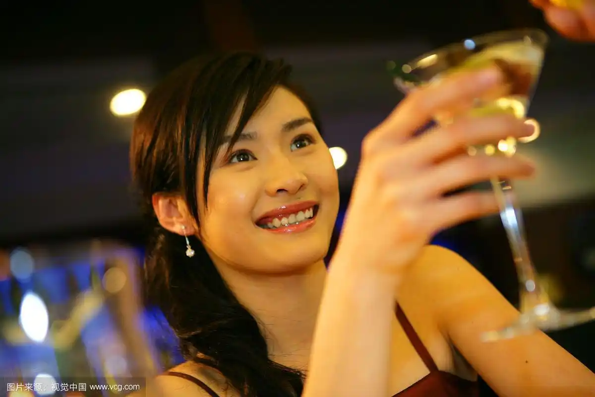 年轻女士在酒店酒吧举杯