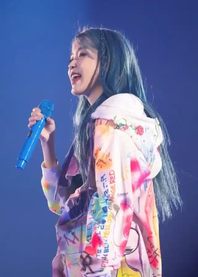 蓝色长发的iu很有魅力,梦幻个性,穿着涂鸦印花的卫衣潮范儿十足,瞬间