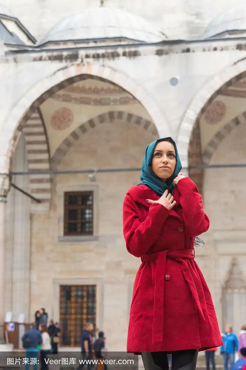 年轻的阿拉伯妇女戴着面纱在清真寺前