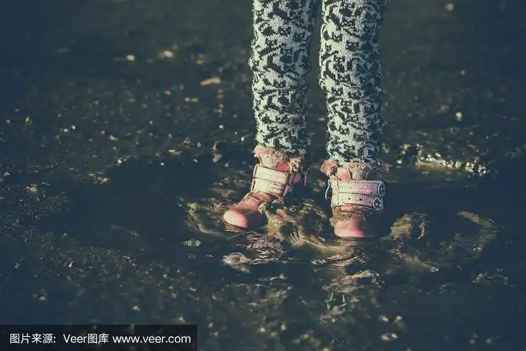 小女孩在水里玩耍,湿了脏兮兮的鞋子,在水坑中间,难忘的时刻,孩子们的